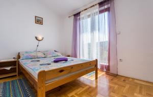 sypialnia z łóżkiem i dużym oknem w obiekcie Apartman Ceković w mieście Šilo