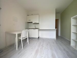 cocina blanca con mesa blanca y sillas en Bottrigo Apartment, en Bardolino