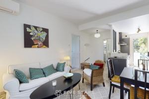 ein Wohnzimmer mit einem weißen Sofa und einem Tisch in der Unterkunft Villa Capriciosa - Five Stars Holiday House in Beaulieu-sur-Mer