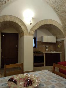 a kitchen with arched ceilings and a table with at Soggiornare In Centro in Alberobello