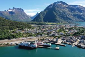 a cruise ship docked at a dock in the mountains at Åndalsnes Sentrum 1-roms Apartment in Åndalsnes