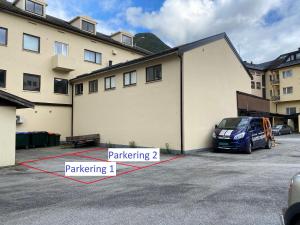 a car parked in a parking lot next to a building at Åndalsnes Sentrum 1-roms Apartment in Åndalsnes