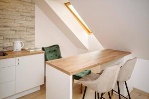 une cuisine avec une table en bois et deux chaises dans l'établissement RBRoom, à Vilnius