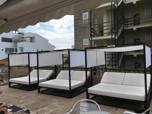 a group of white chairs sitting on a balcony at Apartamentos Carabela II in Paguera