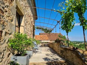 un patio con sillas y una mesa en un edificio en Les Peyronnies, en Figeac