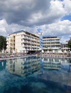a large swimming pool with chairs and a hotel at Aquamarine Hotel - All Inclusive in Sunny Beach