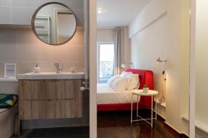 y baño con cama, lavabo y espejo. en Scala_Apartment en Kalamata