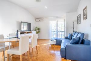 a living room with a blue couch and a table at Apartment Pelicaric Sali Dugi otok in Sali