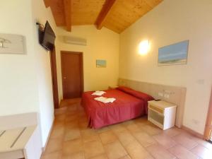 1 dormitorio con 1 cama roja en una habitación en Tenuta il Giogo, en Monterado