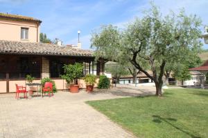 a patio with a table and chairs and a tree at Tenuta il Giogo in Monterado