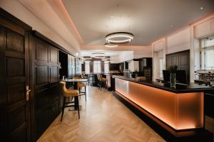 kuchnia z czarnymi szafkami i bar z stołkami w obiekcie Seehotel Billroth w mieście St. Gilgen