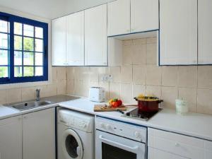cocina blanca con lavavajillas y fregadero en Villa Julie, en Protaras