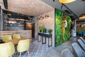 a green wall in a restaurant with a table and chairs at Хотел Камъните in Burgas City