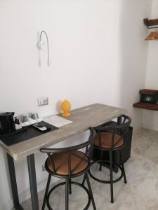 une table avec deux chaises noires et une table avec un bureau dans l'établissement B&B Mario Relais, à Sorrente