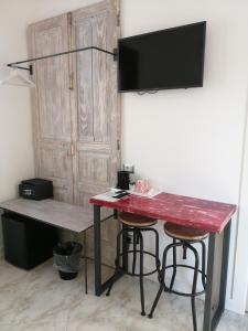 une table rouge avec deux tabourets et un bureau dans l'établissement B&B Mario Relais, à Sorrente
