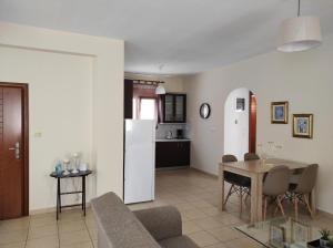 a kitchen and living room with a table and a refrigerator at Elena House in Néa Péramos