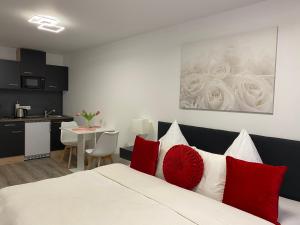 um quarto com uma cama com almofadas vermelhas e brancas em Prime Host Sophie Apartments em Karlsruhe