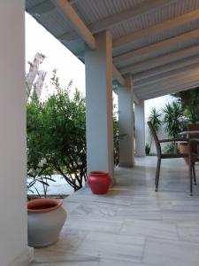 - une terrasse couverte avec 2 casseroles, une table et des chaises dans l'établissement Theros & Trygos Boutique Houses - ATH Airport, à Artemi