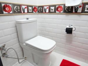 a white toilet in a bathroom with black and white tiles at Istanberry - Berry Life Apartments in Istanbul