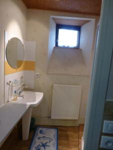 a bathroom with a sink and a mirror and a window at Le Logis de la Cour de Bretagne au Port de Dinan Lanvallay in Lanvallay