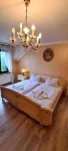 duże łóżko w sypialni z żyrandolem w obiekcie Zajazd Motel Staropolski w mieście Pyskowice