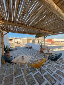 a patio with tables and chairs under a wooden pergola at Salento Boutique Suite in Sant'Isidoro