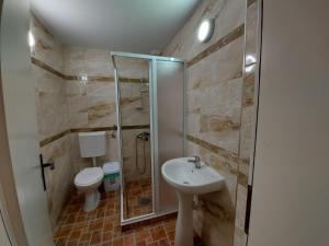 ein Badezimmer mit Dusche, Toilette und Waschbecken in der Unterkunft Villa art colony in Ohrid