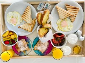 a tray of breakfast food with eggs and toast at Eros Beach Hotel in Benitses