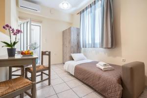 a bedroom with a bed and a desk and a table at Geana Apartments in Chania