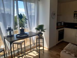 a living room with a table and a window at confortable appartement T2 in La Grande Motte