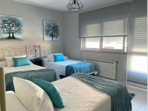 a bedroom with two beds with blue and white at Pensión Pastoriza in Vimianzo