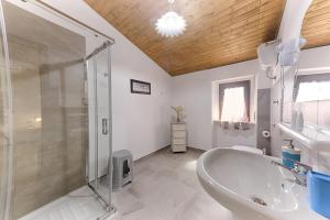 a bathroom with a tub and a glass shower at Casa Lucia in Olbia