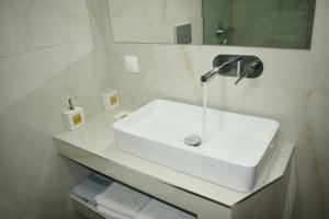 a white bathroom with a sink and a mirror at Kripis Studio in Pefkohori +105 photos