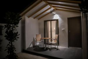 a room with two chairs and a table and a window at RV Thoddoo Maldives - Guest House in Thoddoo