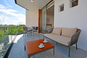 een woonkamer met een bank en een tafel bij MAYAN MONK Suites in Playa del Carmen