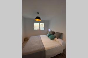 Un dormitorio con una cama en una habitación blanca. en PRECIOSO APARTAMENTO A ESTRENAR EN CENTRO DE NERJA, en Nerja