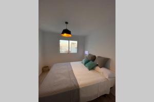 a bedroom with a bed in a white room at PRECIOSO APARTAMENTO A ESTRENAR EN CENTRO DE NERJA in Nerja