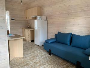 Ожина في Szack: غرفة معيشة بها أريكة زرقاء وثلاجة