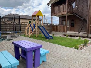 a playground with a slide and benches in a yard at Ожина in Szack