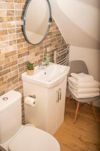 a bathroom with a sink and a toilet and a mirror at Forty Winks Loch Lomond in Balloch +48 photos