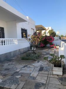 a stone patio with a white building and flowers at Vivenda Ladeira in Olhão