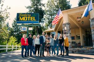 un grupo de personas de pie fuera de un motel en Timbers Motel en Bigfork