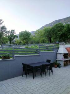 a patio with a table and chairs and a grill at Apartments Nevistic in Tribalj