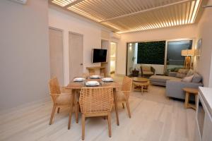 sala de estar con mesa, sillas y sofá en MAYAN MONK Suites, en Playa del Carmen