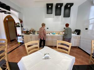 two women standing in a kitchen preparing food at Joan Guesthouse in Përmet