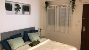 a bedroom with a bed with blue and green pillows at Villa Tlv רחוב הירקון 27 תל אביב in Tel Aviv