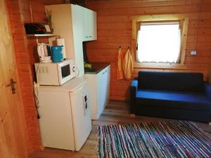 a small kitchen with a microwave and a blue couch at Ferienhaus im fränkischen Seenland - Altmühltal in Eichstätt