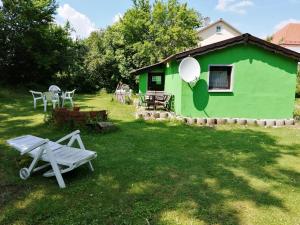 a green house with a picnic table in the yard at Ferienhaus im fränkischen Seenland - Altmühltal in Eichstätt