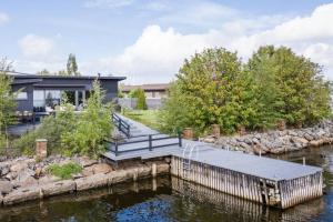 a house with a dock next to a body of water at Reelinki Seafront Villa Aava in Pori