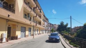 un'auto parcheggiata in una strada accanto agli edifici di La Cattolica a Stilo